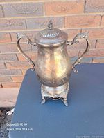 Full view of silver-plated urn showing lid, handles, base
