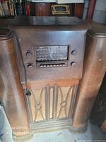 Full view of wooden console radio cabinet with dial and speaker grill