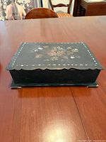 Top view of writing box showing floral inlay and scalloped edges