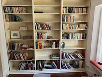 Full view of five built-in shelves filled with books
