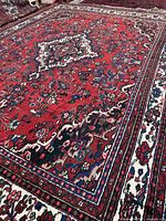 Overall view of Hamdan rug showing red field and beige borders