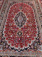 Full view of Mashad rug showing red field and blue medallion