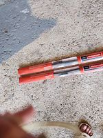 Two sealed Motorcraft wiper blades in red tubes on floor