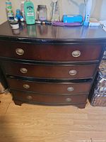 Front view of dark wood bow-front dresser with four drawers