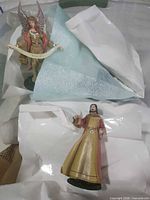 Angel and woman figurines unwrapped