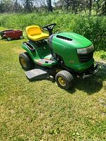 Front-left view of John Deere L110 tractor showing hood, seat, mower deck, tires
