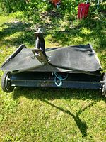 Overall view of lawn sweeper folded with hopper visible
