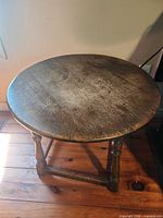 Top view of round wooden side table showing wood grain and wear