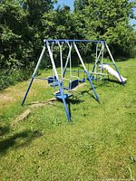 Full view of metal swing set with slide