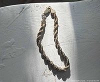 Full view of gold rope chain bracelet laid flat