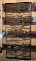 Front view of rectangular metal wall art showing twig-style rods inside frame