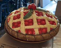 Side view of ceramic covered pie dish showing cherry lattice lid and brown base