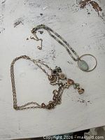 Both necklaces laid out showing full lengths and pendants