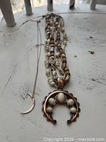 Full view of both necklaces laid out to show length and pendants