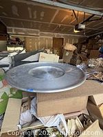 Side perspective of large metal lazy Susan on cartons