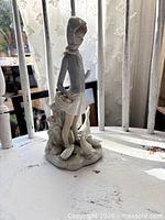 Front angled view of Lladro figurine showing girl, basket and geese