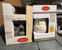 Front view of both boxed fragrance warmers showing skull and owl designs