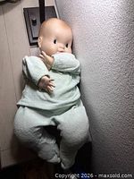 Full view of doll seated wearing mint green outfit