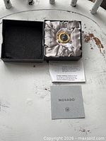 Movado desk clock in open box with foam lid insert, paperwork visible
