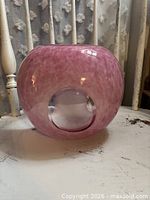 front view of spherical pink mottled glass vase with clear circle