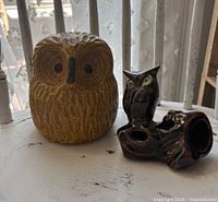 Front view of both owl figurines on white surface