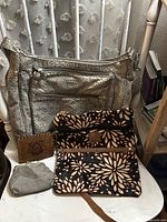 All four items together: Travelon purse, floral wristlet, brown leather wallet, gray suede coin purse