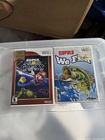 Front view of two Wii game cases: Super Mario Galaxy Nintendo Selects and Rapala We Fish!