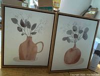 Front view showing both floral canvas prints in frames