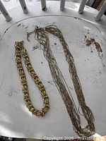 Both necklaces laid flat showing overall design and length comparison