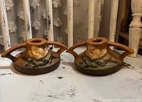 Front angled view of both Roseville Magnolia candle holders showing blossom motif and handles