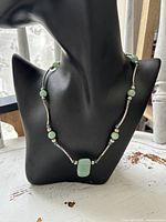 Full view of sterling silver and jade bead necklace on display bust