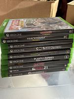 Front view of stacked Xbox One game cases showing most titles