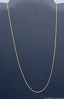 Full view of the gold cable necklace chain hanging to show overall length and style