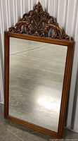 Full view of mirror showing frame and carved crest