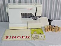 Front view of Singer 9224 machine with manuals, thread spools, power cord