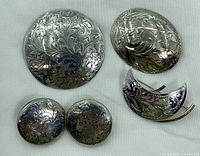 Front view of all five sterling silver pieces showing floral engraving