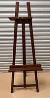 Full view of wooden artist easel standing upright
