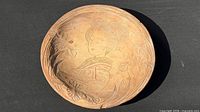Top view showing carved female figure and floral design inside bowl