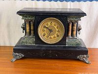 Front view of mantel clock showing full case and dial