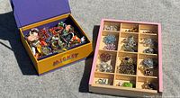 Overall view of Mickey box filled with jewelry and wooden tray with brooches