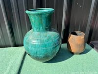 Large turquoise glazed vase front view, brown vase beside