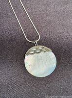 Close-up of pendant showing mother-of-pearl, marcasite cap and bail on snake chain