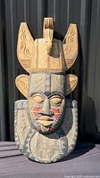 Full view of large carved and painted wooden mask