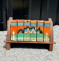 Front view of six miniature boxes in wooden stand