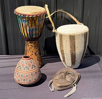 Group shot showing two drums, pottery vase and wood mask
