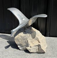 Left side view of full goose sculpture on stone base