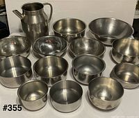Group shot of stainless steel pitcher and thirteen mixing bowls