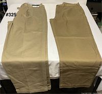 Both pairs of khaki pants laid flat side by side on table