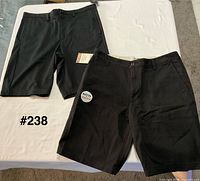 Both pairs of black shorts laid flat showing overall appearance and color