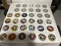 All 34 DVD discs laid out in rows, showing mix of printed and silver discs in sleeves